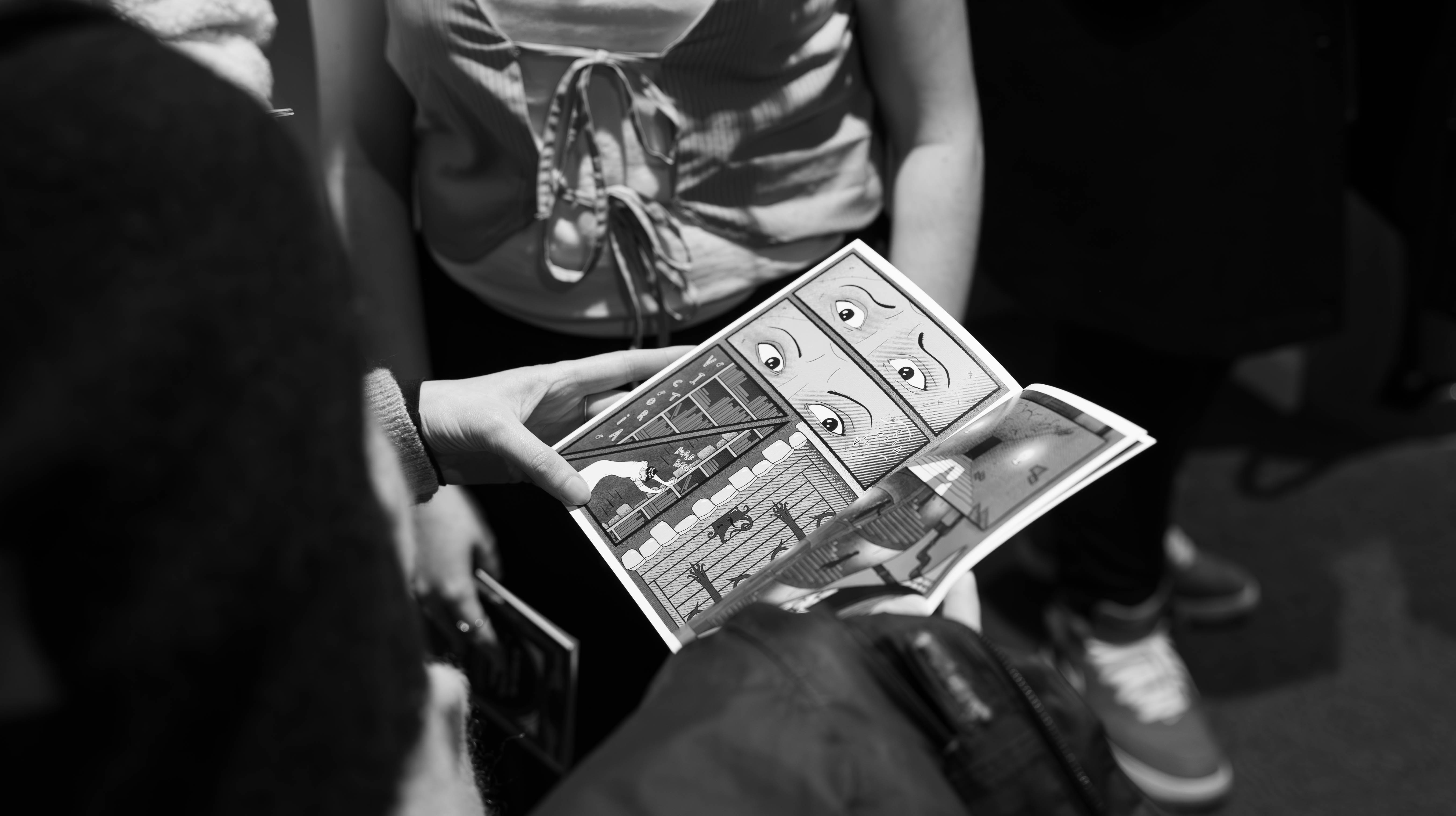 Attendees at the event looking at the comic book 'Crooked Seams'
